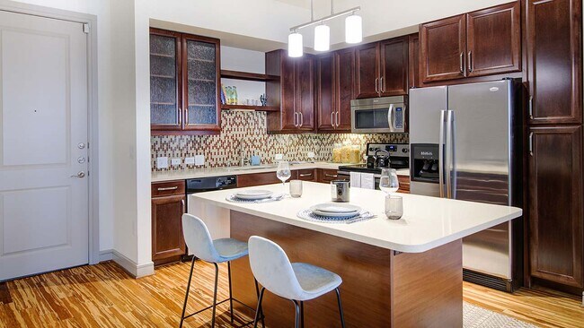 Cocina del apartamento Griffis Uptown con encimeras de cuarzo y electrodomésticos de acero inoxidable. - Griffis Uptown