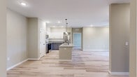 Located at 11010 Garden Trace Drive in Louisville, KY, this well-designed 3-bedroom, 2-bathroom single-story home offers a thoughtful layout with modern finishes throughout. Light wood-tone luxury vinyl plank flooring runs continuously across the entire home, creating a bright and cohesive aesthetic.

The kitchen is a standout feature, boasting two-tone cabinetry with crisp white upper cabinets and slate gray lower cabinets, granite-look countertops, a white subway tile backsplash, and a full suite of stainless steel appliances including a range, microwave, dishwasher, and refrigerator.

The living room is bathed in natural light from sliding glass doors that open directly onto a private balcony, where a railed deck offers pleasant views of the surrounding neighborhood's green landscape. A modern ceiling fan with integrated lighting adds comfort and style to the space.

The primary bedroom features direct access to one of the two bathrooms and is generously proportioned. The second bathroom includes a full tub/shower combo with matte black fixtures. Soft sage and warm greige wall tones carry throughout the bedrooms, lending a calm, neutral palette.

A dedicated laundry room houses a full-size washer and includes wire shelving for additional storage. The home also includes a closet and ample natural light from multiple windows, making it a well-rounded and functional living space.