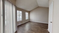 Located at 5119 Medlock Bridge Rd in Peachtree Corners, GA, this one-bedroom, one-bathroom unit offers a well-organized single-floor layout designed for comfortable everyday living. The living room is a standout space, featuring vaulted ceilings that lend an open, airy feel and durable wood-look flooring that flows throughout the main living areas. A ceiling fan adds both function and style, while a louvered closet door provides convenient storage. Natural light filters in through a window, brightening the neutral-toned walls. The kitchen is efficiently laid out in a U-shape configuration, offering ample cabinetry with rich brown finishes, white countertops, and a full suite of black appliances including a refrigerator, range, and over-the-range ventilation hood. Wood-look flooring continues through the kitchen, complementing the warm cabinetry tones. The generously sized bedroom is finished with soft wall-to-wall carpeting and features a large window that frames outdoor greenery, filling the room with natural light. Textured ceilings are present throughout. The bathroom includes a full-size soaking tub and shower combination with clean white surround finishes, set against warm neutral walls. Overall, the unit presents a practical and cohesive design with a neutral palette throughout.