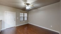 Located at 1509 Centre Place Dr in Denton, TX, this 2-bedroom, 3-bathroom single-floor residence offers a well-organized layout designed for functional living. The open-concept living area features rich hardwood-style flooring, neutral taupe walls, and a ceiling fan with integrated lighting, creating a clean and inviting atmosphere. Natural light filters in through blinds-fitted windows, adding warmth to the space.

The kitchen is a standout feature, equipped with light maple cabinetry, dark laminate countertops, black appliances including a refrigerator, range, and built-in microwave, and a peninsula breakfast bar illuminated by stylish pendant lights—ideal for casual dining and meal prep.

Both bedrooms are carpeted with a patterned grey carpet, each outfitted with a ceiling fan. The primary bedroom includes access to a dedicated closet and connects to a bathroom featuring a granite-topped vanity, hardwood-style flooring, and in-unit laundry facilities. A second bathroom includes a full soaking tub with a tiled surround in earthy brown tones. A second closet provides additional storage. The second bedroom benefits from a large window with outdoor views, allowing for ample natural light throughout the day.