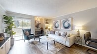 This 1-bedroom, 1-bathroom residence is a thoughtfully designed single-floor unit that maximizes every inch of its compact footprint. Wood-look flooring runs throughout, providing a cohesive and warm aesthetic across all rooms.

The living room is bright and inviting, featuring a textured ceiling, crown molding, and a sliding glass door that opens to an outdoor balcony, allowing natural light to fill the space. Built-in shelving adds functional character, while the open sightlines create an airy feel.

The kitchen is efficiently appointed with stainless steel appliances — including a range, microwave, and refrigerator — complemented by white cabinetry and granite-look countertops. A decorative arched mirror adds a stylish touch to the space.

The bedroom offers a comfortable retreat with a ceiling fan, crown molding, and a large window that invites natural light. A sliding closet provides practical storage, keeping the room uncluttered and functional.

The bathroom is clean and well-finished, featuring a tub-shower combination, white subway tile surround, granite-look vanity countertop, and white cabinetry — delivering a polished, neutral aesthetic throughout. Together, these rooms form a cohesive, livable space with consistent finishes and a calm, neutral palette.
