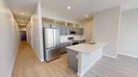 Located in the heart of Minneapolis at 602 2nd Ave S, this thoughtfully designed 2-bedroom, 2-bathroom unit offers a well-organized single-level layout with a cohesive modern aesthetic. Light wood-look flooring runs throughout, complemented by neutral gray and white walls and crisp white trim with matte black hardware accents.

The open-concept kitchen and living area serves as the centerpiece of the unit. The kitchen is equipped with stainless steel appliances, including a full-size refrigerator, range, and microwave, alongside gray shaker-style cabinetry and a generous island with a white countertop and undermount sink — ideal for both cooking and casual dining.

Both bedrooms are well-proportioned, with the primary bedroom offering a comfortable footprint and access to dedicated closet space. A second bedroom features clerestory windows near the ceiling, allowing natural light to filter in while maintaining privacy. Each room benefits from the consistent light flooring and neutral palette.

The two bathrooms are finished in a matching modern style. One features a full tub-shower combo with a gray vanity and black-accented fixtures, while the second offers a clean, efficient layout with a gray cabinet vanity and lighted mirror. Two closets provide practical storage throughout the unit, rounding out this well-appointed Minneapolis residence.