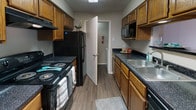 Located at 4400 Holiday Hill Rd in Midland, Texas, this single-story residence offers a practical and comfortable layout designed for everyday living. The galley-style kitchen is well-appointed with warm oak cabinetry lining both walls, dark speckled countertops, and black appliances including an electric range, refrigerator, and built-in microwave. A stainless steel sink and wood-look flooring complete the functional yet attractive kitchen space.

The bedrooms feature plush neutral carpeting and light-toned walls, creating a calm and restful atmosphere. Windows with vertical blinds allow natural light to filter in, enhancing the open feel of each room. The textured ceilings are consistent throughout the living areas.

Two bathrooms serve the residence, each finished with the same dark speckled countertops and rich wood vanity cabinetry found in the kitchen. The primary bathroom includes a wide vanity with a large mirror and overhead lighting, while the secondary bathroom offers a tub/shower combination. Hardwood-look flooring in the bathrooms ties the finishes together cohesively. The overall design is straightforward and consistent, offering a move-in-ready space in a residential Midland neighborhood.