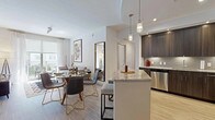 This single-floor residence showcases a thoughtfully designed interior with a contemporary aesthetic carried consistently throughout. The kitchen is a standout feature, outfitted with rich dark-wood cabinetry, light granite countertops, a neutral tile backsplash, and a full suite of stainless steel appliances including a range, built-in microwave, and dishwasher. Light wood-style flooring anchors the space and continues into the adjoining hallways, lending warmth and visual continuity.

Multiple bedrooms are present, each finished with the same light flooring, crisp white walls, and ceiling fans that contribute to a bright, airy atmosphere. Natural light filters in through windows dressed with sheer curtains, creating a soft and inviting ambiance. Several bedrooms include access to walk-in closets or adjoining spaces, adding functional appeal.

The bathrooms are finished with large-format marble-style porcelain tile, maintaining a clean, upscale look. One bathroom features a frameless glass walk-in shower with marble-surround walls and a built-in teak bench, while another offers a soaking tub with matching marble surround. Dark wood vanities with white countertops and chrome fixtures complete the refined look throughout.