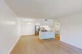 Located at 3334 W Caldwell Ave in Visalia, California, this well-appointed one-bedroom, one-bathroom unit offers a clean, modern aesthetic throughout its efficiently designed single-floor layout. The open-plan kitchen and living area serves as the heart of the home, featuring light hardwood flooring that extends across the main living space. The kitchen is outfitted with white shaker-style cabinetry, granite-look countertops, a peninsula with a gas cooktop, a stainless steel refrigerator, dishwasher, and range — all complemented by a stylish chandelier overhead. A private exterior door in the living area allows for direct outdoor access and brings in natural light alongside a large window. The bedroom is carpeted for comfort, equipped with a ceiling fan, and includes a window with views of the surrounding greenery, as well as access to a dedicated closet. A hallway connects the main living areas to the bathroom, which features a full tub/shower combination, a white vanity with granite-look counters, and hardwood-style flooring. The unit presents a clean, neutral palette throughout, making it a bright and versatile living space.