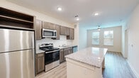 Located in Smyrna, GA, this well-appointed one-bedroom, one-bathroom residence offers a thoughtfully designed layout across a single floor. Light hardwood-style flooring flows throughout, creating a cohesive and bright aesthetic from room to room.

The open-concept kitchen is a standout feature, showcasing rich medium-toned cabinetry, a classic subway tile backsplash, and gleaming granite countertops. A central island provides additional prep space and casual seating, while a full suite of stainless steel appliances — including a refrigerator, range, microwave, and dishwasher — completes the space. Recessed lighting overhead keeps the kitchen bright and functional.

The living area extends naturally from the kitchen, bathed in natural light from large windows with slatted blinds, and is finished with a ceiling fan for year-round comfort. The bedroom is generously sized with dual windows offering outdoor views, its own ceiling fan, and direct access to both the bathroom and ample closet space. The walk-in closet features extensive wire shelving for efficient organization.

The bathroom is clean and modern, outfitted with a walk-in shower featuring brushed nickel grab bars and fixtures. A dedicated utility room and additional closet round out this efficiently arranged home, making it a practical and comfortable living space.