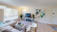 Located at 3207 Hewitt Avenue in Silver Spring, Maryland, this single-floor residence offers a thoughtfully organized layout with comfortable living spaces throughout. The open living room is generously proportioned, featuring neutral-toned carpeting, soft natural light from a large window with blinds, and ample wall space for artwork. The room connects seamlessly to the rest of the unit, creating an easy flow for everyday living. Adjacent to the living area, the dining space accommodates a full dining table and chairs, with a sliding glass door fitted with vertical blinds that allows natural light and offers views of the surrounding greenery outside.

The kitchen is well-equipped with white cabinetry, stainless steel appliances including a gas range, dishwasher, and refrigerator, as well as a double sink and light-toned countertops. A built-in shelving nook provides additional storage. Light tile flooring completes the practical, clean aesthetic.

A carpeted hallway connects two bedrooms, each featuring windows that bring in natural light. One bedroom includes a dedicated vanity area with a built-in sink, cabinetry, and a large mirror, adding a functional and private grooming space. Throughout, the unit maintains a consistent neutral palette, contributing to a calm and welcoming ambiance.