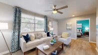 Located at 1400 S Nova Rd in Daytona Beach, FL, this well-appointed 2-bedroom, 1-bathroom single-story home offers a thoughtfully designed layout with a coastal-inspired aesthetic. The living room is bright and welcoming, featuring wood-look flooring, a ceiling fan, and large windows that allow an abundance of natural light to fill the space. A striking teal accent wall serves as a bold focal point, complementing the neutral tones found throughout the home.

The open living and dining area flows naturally together, creating an inviting space ideal for both relaxing and entertaining. The kitchen features white cabinetry, granite-look countertops, a mosaic tile backsplash, and stainless steel appliances, all finished with light tile flooring.

Both bedrooms continue the coastal color theme, each showcasing vibrant teal accent walls, plush carpeting, and ceiling fans. The primary bedroom offers a comfortable, well-proportioned layout with ample closet space.

The bathroom is finished with clean white tile flooring, a white vanity with chrome hardware, and a tub-shower combination. Consistent design choices—from the coastal artwork to the carefully chosen color palette—give this home a cohesive, polished character throughout.