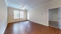 Located at 501 Grand Blvd, Unit 306 in Kansas City, Missouri, this one-bedroom residence offers a well-designed single-level layout with a thoughtful mix of finishes and functional spaces. The open-concept kitchen and living area serves as the heart of the unit, featuring rich hardwood-style flooring, crown molding, and abundant natural light from large windows. The kitchen is well-appointed with warm wood cabinetry, white subway tile backsplash, light countertops, and a full suite of stainless steel appliances including a refrigerator, range, microwave, and dishwasher. A peninsula with an extended counter provides additional prep space and separates the kitchen from the living area. The living room benefits from a ceiling fan, crown molding, and direct access to an exterior door. The spacious primary bedroom features plush wall-to-wall carpeting, a ceiling fan, and a window that brings in natural light. An attached bathroom with a tub/shower combo and direct access to a closet completes the private quarters. A dedicated hallway and closet provide additional storage. Neutral wall tones throughout create a clean, versatile backdrop suitable for a variety of interior styles.