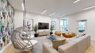 Located at 4520 Charlotte Park Dr in Charlotte, NC, this single-floor space offers a cohesive, modern design with an open, airy layout. The living room serves as the centerpiece, showcasing warm natural hardwood flooring, recessed linear LED lighting, and crisp white walls. A dramatic floor-to-ceiling abstract mural adds a bold artistic statement, while a suspended wicker hanging chair contributes a playful, contemporary touch. Comfortable seating, a glass coffee table, and lush potted palms create an inviting atmosphere, complemented by a large window that brings in natural light and outdoor views. The kitchen is equally well-appointed, featuring dark matte cabinetry, sleek dark countertops, a center island with an integrated sink, stainless steel appliances, and elegant pendant lighting. Generous windows flood the kitchen with natural light, highlighting the warm hardwood floors that flow seamlessly throughout the space. The hallway connects the rooms efficiently, maintaining the clean, minimalist aesthetic found throughout. Overall, the space strikes a refined balance between modern design and artistic expression, creating an environment that is both functional and visually dynamic.