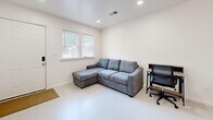 Located at 640 Rouge Bluff Road in Memphis, TN, this single-floor, one-bedroom, one-bathroom home offers a clean and modern aesthetic with a bright, minimalist design throughout. The open-concept layout efficiently combines the living, dining, and kitchen areas into a cohesive and functional space. The kitchen is well-appointed with white shaker cabinetry, granite countertops, and a full suite of stainless steel appliances including a refrigerator, range, microwave, and dishwasher, all illuminated by recessed lighting. The combined dining area provides space for a dining table, while the living area features a wall-mounted television, a sectional sofa, and natural light streaming in through windows with blinds. The bedroom is a cozy, light-filled retreat with two windows offering outdoor views, wall-mounted shelving, and a closet. The bathroom maintains the home's clean design language with a white vanity, granite countertop, and a well-lit mirror. Consistent light-toned flooring, crisp white walls, and clean trim run throughout, creating a cohesive and inviting atmosphere across the entire home.