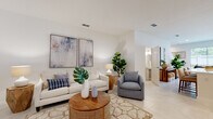 Located at 3638 Caravelle St in Sarasota, Florida, this two-story home offers a thoughtfully designed layout with clean, contemporary finishes throughout. The main level is defined by an open-concept floor plan where the living, dining, and kitchen areas flow seamlessly together. Large-format tile flooring extends across this level, contributing to a bright and cohesive aesthetic. Recessed lighting illuminates the space, complementing the crisp white walls and neutral palette.

The kitchen is well-appointed with gray shaker-style cabinetry, white quartz countertops, stainless steel appliances, and a central island with seating—ideal for both everyday meals and casual entertaining. The living area provides generous space for multiple seating arrangements, while a dedicated dining zone adds functional versatility.

A full bathroom on the main level features white tile, a tub-shower combination, and a single-sink vanity with coordinating cabinetry. Upper-level rooms are finished with plush carpet and include ceiling fans, with one bedroom offering a private en-suite bath. Additional carpeted rooms provide flexible use as bedrooms or secondary living spaces.

The attached garage features a concrete floor and built-in shelving for storage. A dedicated laundry area houses a full-size washer and dryer.