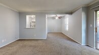 Located at 12445 W 97th Ter in Lenexa, KS, this single-floor, three-bedroom, two-bathroom home offers a practical and comfortable layout. The living room serves as the heart of the space, featuring soft wall-to-wall carpeting, a ceiling fan with light fixture, crown molding, and a pass-through window opening directly to the kitchen, which is equipped with stainless steel appliances. Natural light filters in through windows fitted with blinds, brightening the neutral gray walls throughout.

Each of the three bedrooms continues the carpeted flooring and light gray color palette, maintaining a consistent and calming aesthetic. The bedrooms feature windows that allow in natural light, textured ceilings, and clean white trim. The primary bedroom includes a direct connection to one of the bathrooms, offering added privacy and convenience.

The bathrooms are designed with functionality in mind, featuring white subway tile surrounds in the tub/shower areas and brushed nickel grab bars for added accessibility and safety. Wood-look flooring in the bathroom areas complements the clean, bright finishes throughout.

A connecting hallway ties the rooms together efficiently. Overall, the home presents a clean, move-in ready environment with consistent finishes and a straightforward, well-organized floor plan.