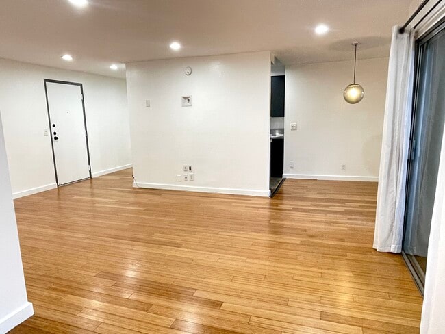 TV wall with kitchen behind. Kitchen open on both sides - 525 N Sycamore Ave
