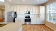 Located at 728 N Church St in Spartanburg, SC, this single-floor residence offers a well-designed layout with modern finishes and a clean, contemporary aesthetic. A welcoming hallway with hardwood-style flooring leads into the open-concept living and kitchen area, where natural light streams through multiple windows. The kitchen is a standout feature, boasting crisp white cabinetry with sleek hardware, light quartz countertops, a classic subway tile backsplash, and stainless steel appliances including a refrigerator, electric range, and over-the-range microwave. A central island provides additional prep and dining space. The living area continues the warm hardwood-style flooring and includes a ceiling fan, with views to adjacent rooms. Bedrooms are finished with plush carpeting, ceiling fans, and windows fitted with blinds that allow for natural light and privacy. The bathrooms are thoughtfully appointed — one features a glass-enclosed walk-in shower with large-format gray tile, while another offers a soaking tub with a coordinating tiled surround and brushed nickel fixtures. Neutral wall tones and consistent trim work tie the entire space together, creating a cohesive and inviting atmosphere throughout.