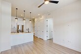 Located at 2825 W 11th St in Houston, TX, this thoughtfully designed one-bedroom, one-bathroom residence offers a clean, modern aesthetic throughout its single-floor layout. Light wood flooring flows seamlessly through every room, complementing the crisp white walls and creating a bright, airy atmosphere.

The open-concept kitchen, dining, and living area serves as the heart of the home. The kitchen is well-appointed with white shaker cabinetry, subway tile backsplash, a large quartz-topped island with an undermount stainless steel sink, sleek pendant lighting with matte black hardware, and a full suite of stainless steel appliances including a French door refrigerator, range, over-the-range microwave, and dishwasher. A ceiling fan overhead adds comfort to the combined living and dining space, which opens to a private balcony through glass French doors framed by transom windows, bringing in generous natural light.

The bedroom is generously proportioned, featuring multiple windows with views to the outdoors, a ceiling fan, and access to two closets for ample storage. A dedicated laundry area adds everyday convenience.

The bathroom is elegantly finished with large-format tile flooring, a glass-enclosed walk-in shower with marble-style tile surround, a white vanity with quartz countertop, and matte black fixtures throughout.