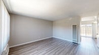 Located at 713 E Travis in Fairfield, CA, this two-story home offers a practical and well-organized layout spread across two floors. The main level hosts a combined kitchen and living area, featuring durable wood-look luxury vinyl plank flooring throughout. The kitchen is equipped with stainless steel appliances — including a gas range, microwave, and refrigerator — complemented by white cabinetry and granite-style countertops. A sliding glass door off the kitchen provides direct access to a private outdoor patio area, bringing in natural light and a seamless indoor-outdoor connection. The living room includes a wall-mounted heating unit and two closet doors for added storage. Upstairs, both bedrooms are finished with plush carpet, neutral-toned walls, and textured ceilings. The generously sized primary bedroom features a large sliding-door closet and a window dressed with vertical blinds. The second bedroom also benefits from natural light and connects conveniently to the staircase landing. The shared full bathroom offers a clean, white tiled tub-shower combination with built-in shelving and chrome fixtures. A dedicated staircase connects both levels, completing this functional and comfortable two-story home.