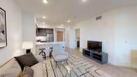 Located on Wilshire Boulevard in the heart of West Los Angeles, this single-floor residence offers a thoughtfully designed open-concept layout with clean lines and contemporary finishes throughout. Light wood-tone flooring runs seamlessly across the living areas, enhancing the bright, airy atmosphere created by recessed lighting and white walls.

The living area is spacious and well-proportioned, providing ample room for a full seating arrangement and dining set, with direct visual connection to the kitchen. The kitchen is a standout feature, outfitted with flat-front cabinetry in a warm woodgrain finish, white quartz countertops, a subway tile backsplash, and a full suite of stainless steel appliances including a gas range, microwave, and refrigerator. A peninsula with bar seating serves as a natural divider between the kitchen and living space.

The bedroom is a calm, well-lit retreat featuring a ceiling fan, a large window with a roller shade, and direct access to a closet. The bathroom is clean and modern, with full white subway tile surrounding a soaking tub and shower combination, paired with light porcelain tile flooring. Every area of this residence reflects a consistent, modern aesthetic well-suited for comfortable urban living in Los Angeles.
