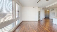 Located at 2949 Parkwood Blvd in Frisco, TX, this well-appointed 2-bedroom, 2-bathroom residence offers a thoughtfully designed single-floor layout. The open-concept living, dining, and kitchen area forms the heart of the home, bathed in natural light from large windows with blinds. Rich, dark hardwood-style flooring flows throughout the main living spaces, adding warmth and continuity.

The kitchen is a standout feature, showcasing dark espresso cabinetry, granite countertops with a subway tile backsplash, a central island with pendant lighting, and a full suite of stainless steel appliances including a refrigerator, range, microwave, and dishwasher. The living room is spacious and bright, with a ceiling fan and direct access to the patio through a glass door.

Both bedrooms are carpeted and include ceiling fans and generous natural light. The primary bedroom connects to a private bathroom featuring granite vanity countertops and a bathtub, with access to a walk-in closet. A second full bathroom serves the additional bedroom. The unit also includes a dedicated laundry area, utility room, and an abundance of closet storage throughout. The overall ambiance is clean, modern, and move-in ready.