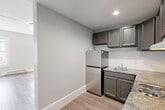 Located in Worcester, MA, this one-bedroom, one-bathroom unit offers a well-organized single-floor layout with clean, updated finishes throughout. Light gray walls and light-toned hardwood-style flooring create a bright, cohesive aesthetic across all rooms.

The combined dining and living room serves as the heart of the unit, featuring two large windows that frame views of the surrounding cityscape, a ceiling light fixture, and baseboard heating. Natural light fills this open area, giving it an airy, comfortable feel.

The kitchen is efficiently designed in an L-shaped configuration, outfitted with gray raised-panel cabinetry, granite-style countertops, stainless steel appliances including a refrigerator and range, a stainless sink, and recessed lighting overhead. The light flooring continues seamlessly from the main living area into the kitchen.

The bedroom is a generously sized private retreat with a large window, baseboard heating, and ample room for furnishings. Two closets provide substantial storage within the unit, supplemented by a dedicated utility room.

The bathroom features warm tile flooring, a dark-toned vanity with under-sink storage, a wall-mounted mirror with lighted fixture, a soaking tub, and a clean, functional layout. A hallway connects the rooms, completing this practical and well-appointed unit.