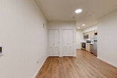 Located at 615 W Nickerson St in Seattle's Queen Anne neighborhood, this efficiently designed studio unit makes smart use of its compact footprint across a single floor. The open-plan living, dining, and kitchen area is unified by warm-toned luxury vinyl plank flooring and crisp white walls, creating a clean, modern aesthetic throughout. Recessed lighting illuminates the space evenly, enhancing its bright and airy feel. A window near the entry door allows natural light to filter in, adding warmth to the living area.

The kitchen is well-appointed with light wood cabinetry, white quartz countertops, and a full suite of stainless steel appliances, including a refrigerator, electric range, built-in microwave, and dishwasher. Ample upper and lower cabinet storage ensures functional use of the kitchen space.

Two louvered bi-fold closet doors provide generous storage within the main living area. The full bathroom features a combined tub and shower with clean white surrounds, toilet, and continued wood-look flooring for a cohesive finish. An in-unit laundry area adds everyday convenience. This thoughtfully laid-out unit offers a practical and modern living environment suitable for those seeking efficiency without sacrificing essential amenities.