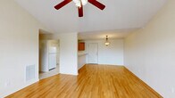 Located at 1801 Century Blvd in Opelika, Alabama, this single-story, 3-bedroom, 2-bathroom home offers a well-organized layout designed for comfortable everyday living. The open-concept living area features warm hardwood-style flooring, vaulted ceilings, a ceiling fan, and large windows that fill the space with natural light, along with a glass door providing direct outdoor access. A pendant light fixture adds a finishing touch to the dining area.

The kitchen is positioned adjacent to the living space and features a breakfast bar peninsula, warm wood cabinetry, white appliances including a refrigerator and electric range, a microwave, and a textured ceiling. The layout allows for easy interaction between the kitchen and living areas.

Each of the three bedrooms is appointed with hardwood-style flooring and ceiling fans. The primary bedroom is generously sized and includes a dedicated walk-in closet with wire shelving on multiple walls, offering substantial storage. The primary bathroom is highlighted by a corner soaking tub with tile surround and a window for natural light, while the second bathroom features a full tub-shower combo with clean white finishes and tile flooring. A hallway connects the bedrooms efficiently throughout the home.
