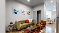 This 1-bedroom, 1-bathroom unit offers a thoughtfully designed single-floor layout that makes efficient use of its compact footprint. Polished concrete floors run throughout the entire space, lending an industrial-modern aesthetic that ties each area together cohesively.

The open-concept living area provides a comfortable setting for relaxation, with recessed lighting overhead and crisp white walls that enhance the sense of brightness. A sliding closet door in the living space adds practical storage without encroaching on the room's flow.

The kitchen is fully equipped with a complete suite of stainless steel appliances, including a refrigerator, electric range, built-in microwave, and dishwasher. White shaker-style cabinetry lines the walls, complemented by clean countertops and a functional single-basin sink, offering ample workspace for everyday cooking.

The bedroom provides a generous retreat with room for a full furniture arrangement, and is finished with the same clean white walls and polished floors found throughout.

The bathroom maintains the unit's consistent modern style, featuring a white vanity with under-sink storage, a large wall mirror, and a clean, minimal layout.

A wall-mounted mini-split unit provides climate control, and recessed lighting throughout ensures the space remains well-lit. The overall ambiance is clean, contemporary, and move-in ready.