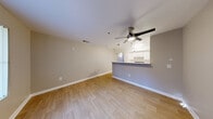 Located at 121 N 15th St in Las Vegas, NV, this 2-bedroom, 1-bathroom unit offers a practical and well-organized single-level floor plan. The open-concept living and dining area is finished with light wood-style flooring and neutral warm-gray walls, creating a clean and cohesive aesthetic. A ceiling fan with integrated lighting provides both comfort and illumination throughout the space.

The kitchen is designed for efficiency, featuring white cabinetry, a white appliance suite including a refrigerator, range, and dishwasher, and a dual-basin stainless steel sink set into a white countertop. A peninsula counter opens directly to the living area, enhancing the sense of connectivity between spaces. Pendant lighting accents the kitchen, adding a functional decorative touch.

The primary bedroom offers a sliding panel closet with built-in hanging storage, while the second bedroom includes a window that brings in natural light. Both bedrooms are finished with the same light wood-style flooring carried throughout the unit.

The bathroom is clean and bright, featuring a single-sink vanity with under-cabinet storage, a large mirror, and a full shower-tub combination. The layout also includes a hallway connecting the main living areas to the bedrooms and bathroom, providing a logical and comfortable flow throughout the unit.