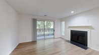 Located at 4401 Hamptonridge Drive in Charlotte, NC, this well-appointed 2-bedroom, 2-bathroom residence offers a thoughtfully designed single-floor layout. The open living room is a welcoming centerpiece, featuring light wood-look flooring, a classic fireplace with a clean white mantel, and a sliding glass door that leads to a private balcony overlooking lush, tree-lined surroundings—filling the space with abundant natural light.

The galley-style kitchen is modern and functional, showcasing white shaker cabinetry, a white subway tile backsplash, quartz countertops, a peninsula with an undermount sink, and a full suite of stainless steel appliances, including a range, microwave, and refrigerator.

Both bedrooms are carpeted for comfort and receive natural light through window blinds. The generously sized primary bedroom offers ample room for furnishings. Each of the two bathrooms mirrors a cohesive aesthetic, with white vanity cabinetry, quartz countertops, a rustic wood-framed mirror, and light hardwood-style flooring.

A dedicated laundry room with full-size washer and dryer hookups adds everyday convenience. A closet provides additional storage. The neutral, light-toned palette throughout the space creates a clean, modern ambiance well-suited to Charlotte living.