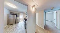 Located at 18 Huntington Circle in Naperville, Illinois, this single-floor unit offers a straightforward and functional layout connecting the kitchen, living spaces, hallway, and bathrooms in a cohesive flow. The kitchen stands out as a well-appointed area, featuring gray cabinetry, white quartz-style countertops, and a classic white subway tile backsplash that extends across the walls. Stainless steel appliances — including a refrigerator, gas range, microwave, and dishwasher — complement the wood-look tile flooring underfoot. A window at the far end of the kitchen brings in natural light and connects visually to an adjacent dining or sitting area equipped with a ceiling fan.

The living and bedroom areas are finished with neutral-toned carpet and painted in soft, light gray tones, creating a calm and cohesive atmosphere throughout. Each room features a window fitted with blinds, allowing for natural light and outdoor views. Baseboard heating runs along the perimeter of these rooms, ensuring efficient warmth. The unit includes two bathrooms, both featuring white tile surrounds in the tub-shower combinations, providing a clean and consistent aesthetic. A central hallway connects all areas of the unit efficiently.