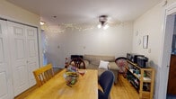 Located at 700 N Second St in Altoona, PA, this single-floor unit offers a practical and comfortable layout designed to accommodate multiple occupants. The open living and dining area serves as the central gathering space, featuring wood-look flooring, a ceiling fan with integrated lighting, and a layout that easily accommodates both a dining table and a seating area. The kitchen is equipped with light wood cabinetry, dark countertops, a stove, refrigerator, and a skylight-style overhead fixture that keeps the space well-lit. Multiple bedrooms are spread throughout the unit, each featuring carpeted floors, ceiling fans, and mirrored sliding closet doors that add depth to the rooms. The bedrooms benefit from natural light through windows dressed with curtains. The full bathroom includes a wood-toned vanity with mirror, an overhead light bar, a wall-mounted storage cabinet, and wood-look flooring, with a window providing natural ventilation. The overall layout, as seen in the floor plan, is elongated and efficiently organized, making it a well-suited option for shared living in the heart of Altoona.