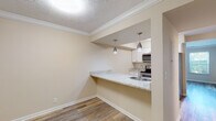 Located in Evansville, Indiana, this two-floor residence offers a thoughtfully arranged layout with updated finishes throughout. The kitchen serves as a functional centerpiece, featuring white cabinetry, granite-style countertops, and a full suite of stainless steel appliances, including a refrigerator, electric range, and dishwasher. A built-in pass-through counter with a sink opens directly to the adjacent living or dining area, where pendant lighting adds a modern touch overhead. Textured ceilings and crown molding detail the main living spaces, lending a polished character to the interior.

The living and dining areas are finished with durable hardwood-style flooring that extends through the main level, providing a clean, cohesive look. Bedrooms are carpeted for added comfort and vary in size, with some rooms featuring natural light from multiple windows with views of the surrounding greenery. The bathroom includes a full tub-shower combination with clean white surroundings and brushed nickel fixtures. Throughout the home, neutral warm tones on the walls create a welcoming and versatile backdrop, making the space adaptable to a range of interior styles.