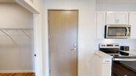 This thoughtfully designed one-bedroom, one-bathroom residence offers a comfortable and functional layout across a single floor. The open-concept living and kitchen area forms the heart of the unit, with light hardwood-style flooring flowing throughout and a bright, neutral color palette that enhances the sense of space.

The kitchen is outfitted with crisp white shaker cabinetry, a subway tile backsplash, light quartz countertops, and a full suite of stainless steel appliances, including a range, microwave, dishwasher, and refrigerator. A large island provides additional prep space and casual seating, while pendant lighting adds a modern touch overhead.

The living room opens directly onto a private balcony through full-height sliding glass doors, flooding the space with natural light and offering expansive outdoor views. The bedroom is generously sized, featuring large windows with scenic views, plush carpet, and a ceiling fan. The bathroom features a white vanity with quartz countertop and a backlit mirror. A dedicated laundry room with a stacked washer and dryer adds convenience, and a separate closet provides ample storage.