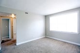 Located at 7703 Major Ave in Norfolk, Virginia, this single-floor residence offers a practical and comfortable layout with well-defined living spaces throughout. The living area is generously sized, featuring neutral-toned carpet, clean white baseboards, and soft gray walls that create a calm, understated atmosphere. Large windows allow natural light to fill the room, enhancing the open feel of the space.

The kitchen is compact yet efficiently arranged, equipped with a gas range, a double-basin stainless steel sink, and ample upper and lower cabinetry featuring wood-trimmed white finishes. A window above the sink brings in additional natural light, and durable tile flooring completes the practical design.

The bedrooms are carpeted and well-proportioned, each featuring neutral walls, windows with blinds, and good closet storage. One bedroom notably includes access to a bathroom and benefits from multiple closets, offering added convenience and storage capacity.

The bathroom features classic floor-to-ceiling tile work in a cream and black accent scheme, a full soaking tub, and a window that provides ventilation and natural light. The overall aesthetic throughout the residence is clean, neutral, and move-in ready, making it a functional and straightforward living space in the Norfolk area.