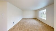Located at 4909 E Upriver Dr in Spokane, WA, this 2-bedroom, 2-bathroom single-floor unit offers a practical and comfortable layout. The combined kitchen and living area serves as the heart of the home, with the kitchen featuring light maple cabinetry, laminate countertops, tile flooring, a white electric range, refrigerator, and a stainless steel sink. The adjacent living room is carpeted and receives natural light through a large window with blinds, creating a bright and open atmosphere.

Both bedrooms are carpeted and offer a clean, neutral palette with windows that bring in natural light. The spacious primary bedroom includes a generous walk-in closet outfitted with wire shelving on multiple walls, providing ample storage. The second bedroom is well-sized and similarly bright.

The two bathrooms are finished with tile flooring and light maple vanity cabinetry with laminate countertops. One bathroom features a tub/shower combo with a large mirror and a strip of vanity lighting above the sink, while the second bathroom provides additional convenience for guests or residents. A hallway connects the main living spaces to the bedrooms and bathrooms, contributing to a well-organized flow throughout the unit.