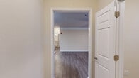Located in Milton, GA, this well-appointed 2-bedroom, 3-bathroom single-floor residence offers a thoughtfully designed layout with modern finishes throughout. The open-concept kitchen and living area serves as the heart of the home, featuring hardwood-style flooring, crown molding, and a ceiling fan. The kitchen is equipped with stainless steel appliances — including a refrigerator, electric range, and over-the-range microwave — complemented by white shaker cabinetry and granite countertops with a built-in sink at the peninsula. The living room receives abundant natural light through large windows and a glass-paneled door that opens directly onto a private balcony with wooded views. The primary bedroom is a comfortable size, fitted with a ceiling fan, generous windows overlooking greenery, and access to a spacious walk-in closet with multi-tier wire shelving. The three bathrooms are finished consistently with granite-topped white vanities, brushed nickel fixtures, and tile-surround tub-shower combinations. Wood-look flooring carries throughout the space, tying the rooms together in a clean, cohesive aesthetic. A dedicated entrance and additional closet storage round out this practical and attractive residence.