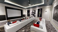 This elegant private screening room delivers a premium cinematic experience wrapped in refined, contemporary design. The space is anchored by a large projection screen mounted on a dark-framed accent wall, paired with a ceiling-mounted projector suspended from a dramatic tray ceiling finished in deep charcoal and outlined with soft ambient LED lighting. Recessed spotlights complement the layered illumination, creating a warm yet moody atmosphere ideal for entertainment.

The room is furnished with multiple oversized white sectional sofas arranged in a theater-style layout, all dressed with bold red and navy accent pillows that introduce rich contrast against the neutral palette. A sleek oval dark coffee table serves as a central focal point between seating arrangements. Underfoot, a textured gray area rug grounds the room and adds depth to the overall design.

The walls are adorned with a curated selection of large-scale abstract black-and-white artworks, each framed within gold-trimmed recessed wall niches that also showcase tall potted plants, lending a polished gallery-like character to the space. Wall sconces provide additional accent lighting throughout.

Together, the architectural details, premium furnishings, and thoughtful art integration make this screening room a standout example of modern luxury design.
