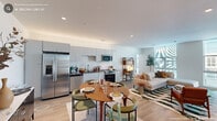 Located at 723 Rigsbee Ave in Durham, NC, this thoughtfully designed 2-bedroom, 4-bathroom residence offers a contemporary living experience across a single floor. The open-concept layout seamlessly connects the kitchen, dining, and living areas, creating a bright and functional shared space. Light hardwood flooring runs throughout, complementing the clean, modern aesthetic.

The kitchen is outfitted with sleek flat-front cabinetry in a soft gray finish, stainless steel appliances including a French door refrigerator, dishwasher, microwave, and range, along with a white square-tile backsplash and ample counter space. A dedicated dining area comfortably accommodates a table for four.

The generously sized primary bedroom features light-filled walls and access to a dedicated closet, while the second bedroom benefits from a large floor-to-ceiling window that brings in abundant natural light and neighborhood views. Both bedrooms maintain a serene, neutral palette.

The bathrooms are finished with crisp white tile work, including textured accent tiling in the shower areas, floating vanities with mirror-front medicine cabinets, and distinctive sage green flooring that adds a modern touch. The overall ambiance throughout the space is clean, contemporary, and welcoming.