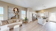 Located in Spring, TX, this single-story, 3-bedroom, 2-bathroom home offers a thoughtfully designed open-concept layout that seamlessly connects the living, dining, and kitchen areas. Light-toned wood-look flooring runs throughout, complementing the neutral warm-beige wall palette and creating a cohesive, airy feel. The living room is bright and welcoming, featuring a ceiling fan, natural light from multiple windows, and a dedicated entry with a glass-panel front door.

The kitchen is a standout feature, showcasing white cabinetry, dark countertops, a classic subway tile backsplash, stainless steel appliances — including a French door refrigerator, range, microwave, and dishwasher — and a central island with pendant lighting above. The space flows naturally into the living area, making it ideal for entertaining.

The three bedrooms offer comfortable proportions, each with ceiling fans and ample natural light. The primary bedroom includes a walk-in closet with built-in shelving. The bathrooms are clean and functional, with one featuring a tub-shower combination with white tile surround and a vanity with stone-look countertops. A dedicated laundry room provides full-size washer and dryer hookups with overhead shelving for added storage.