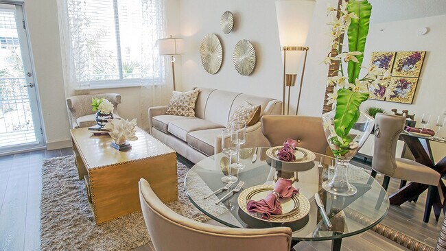 Sala de estar de un apartamento de lujo con mesa de comedor, zona de estar moderna y grandes ventanales con luz natural. - Griffis North Olive