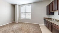 Located at 1430 Madison Ave in Indianapolis, Indiana, this one-bedroom, one-bathroom unit offers a practical and efficiently designed single-floor layout. The open living area features neutral gray walls and plush wall-to-wall carpeting, creating a warm and inviting atmosphere. A large window with blinds allows natural light to fill the space, offering views of the surrounding neighborhood.

The kitchen is well-appointed with rich, dark espresso cabinetry extending to the ceiling for ample storage. It is fully equipped with black appliances, including a refrigerator, electric range with overhead ventilation, and dishwasher, all set against durable countertops with an integrated sink.

The bedroom is a comfortable, carpeted retreat featuring clean neutral walls, multiple electrical outlets, and a sliding-door closet with a built-in hanging rod and shelf, providing organized storage. The space is well-suited for a variety of furniture arrangements.

The bathroom presents a clean, functional design with light tile flooring, a dark wood vanity with a white countertop and sink, a large mirror, and a toilet. The layout is efficient and easy to maintain.

Throughout the unit, consistent neutral tones, white trim, and carpeted floors create a cohesive and understated aesthetic, making this a practical and comfortable residence in Indianapolis.