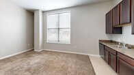 Located at 1430 Madison Ave in Indianapolis, Indiana, this one-bedroom, one-bathroom unit offers a practical and efficiently designed single-floor layout. The open living area features neutral gray walls and plush wall-to-wall carpeting, creating a warm and inviting atmosphere. A large window with blinds allows natural light to fill the space, offering views of the surrounding neighborhood.

The kitchen is well-appointed with rich, dark espresso cabinetry extending to the ceiling for ample storage. It is fully equipped with black appliances, including a refrigerator, electric range with overhead ventilation, and dishwasher, all set against durable countertops with an integrated sink.

The bedroom is a comfortable, carpeted retreat featuring clean neutral walls, multiple electrical outlets, and a sliding-door closet with a built-in hanging rod and shelf, providing organized storage. The space is well-suited for a variety of furniture arrangements.

The bathroom presents a clean, functional design with light tile flooring, a dark wood vanity with a white countertop and sink, a large mirror, and a toilet. The layout is efficient and easy to maintain.

Throughout the unit, consistent neutral tones, white trim, and carpeted floors create a cohesive and understated aesthetic, making this a practical and comfortable residence in Indianapolis.