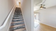 Located in Fort Worth, TX, this two-story home offers a thoughtful layout spread across two floors. The main level features an open-concept living room and kitchen, filled with natural light from large windows and sliding glass doors that lead to a private, fenced backyard with a grassy lawn. The kitchen is a standout, boasting white shaker cabinets, granite countertops, a subway tile backsplash, stainless steel appliances, and a peninsula with additional counter space — all complemented by warm wood-look flooring. A ceiling fan enhances comfort in the living area. Carpeted stairs with white railings lead to the upper level, where the bedrooms are located. The generously sized primary bedroom features plush carpeting, multiple windows with outdoor views, and a ceiling fan. Its en-suite bathroom includes granite countertops, white cabinetry with matte black hardware, wood-look flooring, a tiled shower, and access to a walk-in closet with built-in shelving. A second bedroom, additional bathroom, laundry area, and ample closet space round out the home. Clean, neutral tones throughout create a bright and welcoming ambiance.