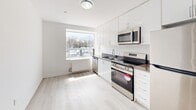 Located at 3101 Eglinton Ave E in Toronto's Scarborough neighbourhood, this two-bedroom, one-bathroom unit offers a clean, modern interior with a thoughtfully organized single-floor layout. Light wood laminate flooring runs throughout the space, complementing the crisp white walls and creating a bright, cohesive aesthetic.

The kitchen is a standout feature, equipped with stainless steel appliances including a refrigerator, electric range, and over-the-range microwave. White cabinetry extends to the ceiling for generous storage, and a dark countertop with an undermount sink adds contrast. A large window floods the kitchen with natural light and offers views of the surrounding area.

Both bedrooms are well-proportioned, with the primary bedroom offering a comfortable footprint. Each room features light-toned flooring, white walls, and windows that bring in natural light. Baseboard heating units are present in the bedrooms, ensuring year-round comfort. A dedicated closet provides practical storage.

The bathroom is finished with classic white subway tile surrounding a full soaker tub, delivering a clean and timeless look. The unit also includes a dedicated closet for additional storage needs. Overall, the space presents a modern, move-in-ready interior with functional design throughout.
