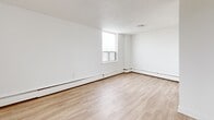 Located on the 8th floor at 10 Highland Cres in Kitchener, Ontario, this one-bedroom, one-bathroom unit offers a clean, modern aesthetic across a well-utilized single-floor layout. Light wood laminate flooring runs throughout, complementing the bright white walls and textured ceilings that give each room a fresh, airy feel.

The entrance leads into a hallway with multiple closets, providing ample storage from the moment you step inside. The kitchen is well-appointed with white shaker-style cabinetry extending to the ceiling, a white subway tile backsplash, dark countertops, and a full suite of stainless steel appliances including a refrigerator, electric range with over-the-range microwave, and dishwasher. A window above the kitchen brings in natural light and exterior views.

The combined living and dining area is generously proportioned, featuring a large sliding glass door that opens onto a private balcony with outdoor views — an ideal spot for relaxing or entertaining. The bedroom offers a comfortable footprint, a large sliding-door closet, and a window that fills the room with natural light. The bathroom is finished with white subway tile surrounding a full soaker tub and shower combination, alongside a clean, simple vanity. Baseboard heating is present throughout the unit.