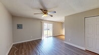 Located at 415 Sylvia Drive in Forest Park, GA, this single-floor, 2-bedroom, 1-bathroom home offers a well-organized and functional layout. The living area is a welcoming space highlighted by rich, dark hardwood-style flooring, neutral warm-toned walls, a textured ceiling, and a ceiling fan with a light fixture. A sliding glass door fills the room with natural light and provides outdoor access, creating an open and airy atmosphere. The kitchen is efficiently designed with white cabinetry, granite-style countertops, a subway tile backsplash, a stainless steel sink, and black appliances including a refrigerator, dishwasher, and gas range. The spacious primary bedroom features soft carpeting, generous proportions, and dual closets, offering ample storage. The second bedroom is also carpeted and receives natural light through a window with blinds. The full bathroom is equipped with a tiled shower-tub combination, providing a clean and classic finish. Hallways connect the rooms, contributing to the home's practical flow. Clean lines, consistent neutral tones, and functional finishes throughout make this home a comfortable and move-in ready residence.