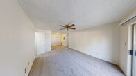 Located at 8500 S 28th St in Fort Smith, Arkansas, this single-floor, one-bedroom, one-bathroom unit offers a practical and well-organized layout. The open-concept main living area seamlessly combines the living room, dining room, and kitchen into one cohesive space, promoting an efficient use of the floor plan. The kitchen is equipped with warm wood-toned cabinetry and a white range, providing a functional cooking environment. The living area features plush carpeting, a ceiling fan, textured ceilings, and a sliding glass door that opens to the outside, allowing natural light to fill the space. The bedroom is generously sized with soft carpet flooring, a ceiling fan, a window that brings in natural light, and access to multiple closets, including a walk-in closet with built-in shelving for ample storage. The bathroom includes a full tub and shower combination with white tile surround. Additional features include a utility room, a hallway connecting the main areas, and multiple closets throughout. The clean, neutral color palette and functional layout make this a comfortable and straightforward living space.