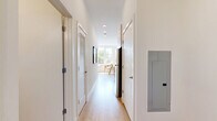Located at 537 Canal St in Stamford, Connecticut, this thoughtfully designed one-bedroom, one-bathroom residence makes excellent use of its compact footprint across a single floor. The open-concept living area is anchored by oversized windows that flood the space with natural light and frame views of lush greenery outside, creating a bright and airy atmosphere. Light-toned hardwood flooring runs throughout, lending warmth and visual continuity to the interior. The living area comfortably accommodates a seating arrangement and dining space, reflecting a practical yet stylish layout. A barn-style sliding door adds a modern architectural detail at the entrance to the bedroom, which features a double-door closet and clean white walls that keep the room feeling serene and uncluttered. The bathroom is finished with stone-toned tile extending from floor to wall, a sleek glass-enclosed walk-in shower, a white vanity with contemporary hardware, and a large mirror — delivering a polished, spa-like feel. A hallway connects the key spaces efficiently, contributing to the smooth flow of the floor plan. The overall aesthetic is clean, contemporary, and filled with natural light, making this Stamford residence a well-appointed urban retreat.
