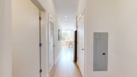 Located at 537 Canal St in Stamford, Connecticut, this thoughtfully designed one-bedroom, one-bathroom residence makes excellent use of its compact footprint across a single floor. The open-concept living area is anchored by oversized windows that flood the space with natural light and frame views of lush greenery outside, creating a bright and airy atmosphere. Light-toned hardwood flooring runs throughout, lending warmth and visual continuity to the interior. The living area comfortably accommodates a seating arrangement and dining space, reflecting a practical yet stylish layout. A barn-style sliding door adds a modern architectural detail at the entrance to the bedroom, which features a double-door closet and clean white walls that keep the room feeling serene and uncluttered. The bathroom is finished with stone-toned tile extending from floor to wall, a sleek glass-enclosed walk-in shower, a white vanity with contemporary hardware, and a large mirror — delivering a polished, spa-like feel. A hallway connects the key spaces efficiently, contributing to the smooth flow of the floor plan. The overall aesthetic is clean, contemporary, and filled with natural light, making this Stamford residence a well-appointed urban retreat.