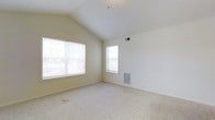 Located at 25 Flagstick Ln in Magnolia, Delaware, this single-floor residence offers a clean, well-maintained living environment with thoughtful architectural details. The interior is highlighted by striking vaulted ceilings that lend a sense of openness and airiness to the living space. Soft, neutral wall tones in a warm cream palette complement the plush wall-to-wall carpeting underfoot, creating a comfortable and inviting atmosphere throughout. Multiple windows allow abundant natural light to fill the space, enhancing the bright and airy feel. The windows are fitted with horizontal blinds, offering both privacy and light control. Climate control is well-integrated, with visible vents positioned strategically along the walls to ensure consistent comfort year-round. The overall design is simple and understated, with clean lines and an open layout that provides flexibility for a variety of furnishing arrangements. The combination of vaulted ceilings, ample natural light, and neutral finishes gives this residence a welcoming and functional character suited to everyday living.